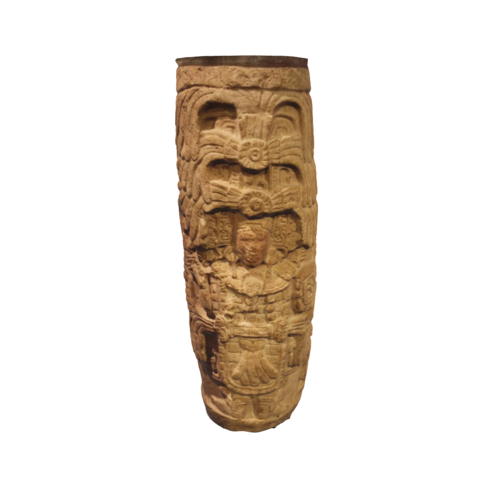 This is a carved stone column typical to the Mayan culture, featuring a standing figure. Mayan columns often depicted rulers, deities or mythological scenes and were integral to their architectural aesthetic.